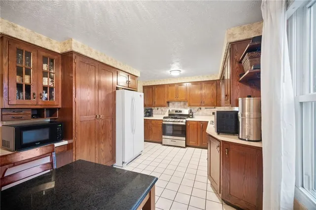 a kitchen with stainless steel appliances granite countertop a refrigerator and a stove top oven
