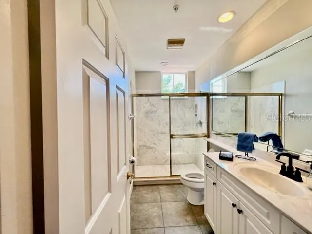 a bathroom with a double vanity sink toilet and mirror