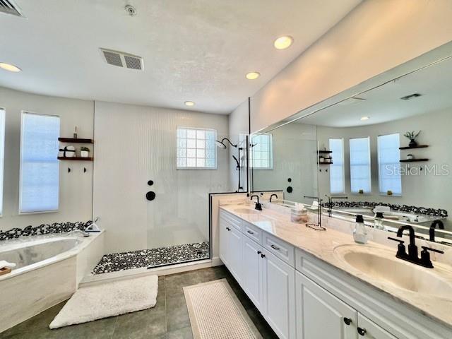 3471 Sunset Key Circle, Unit 102 Punta Gorda, FL 33955 - Photo 28 of 51 a spacious bathroom with a double vanity sink a mirror and a bathtub