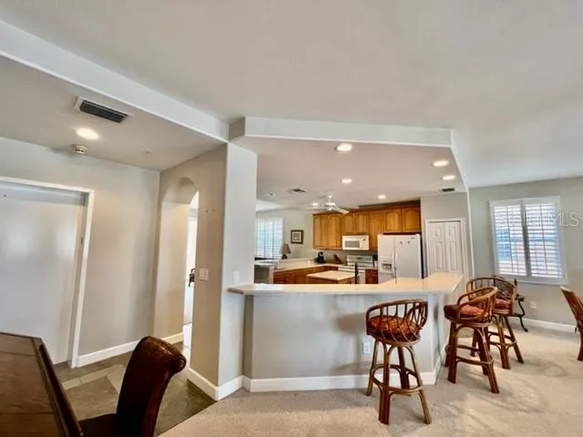 a kitchen with stainless steel appliances kitchen island granite countertop a table and chairs
