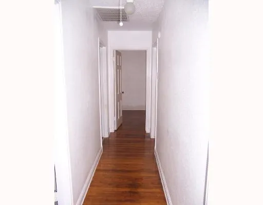 a view of a hallway with wooden floor and a large window