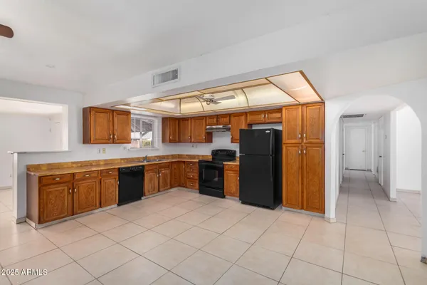 a large kitchen with stainless steel appliances granite countertop a refrigerator and a sink