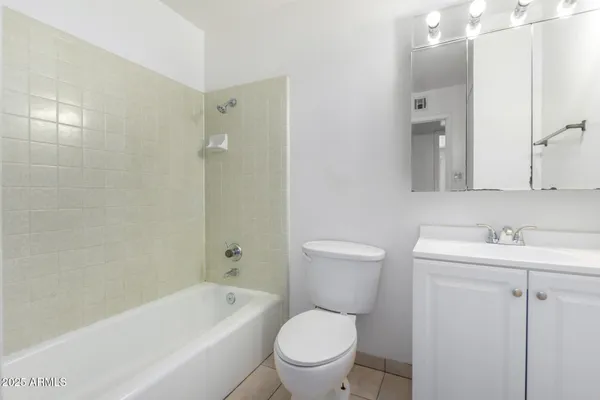 a bathroom with a toilet a sink a mirror a bathtub and vanity