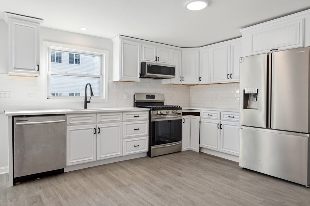 28 Warren Street Peabody, MA 01960 - Photo 9 of 37 a kitchen with cabinets stainless steel appliances a sink and wooden floor