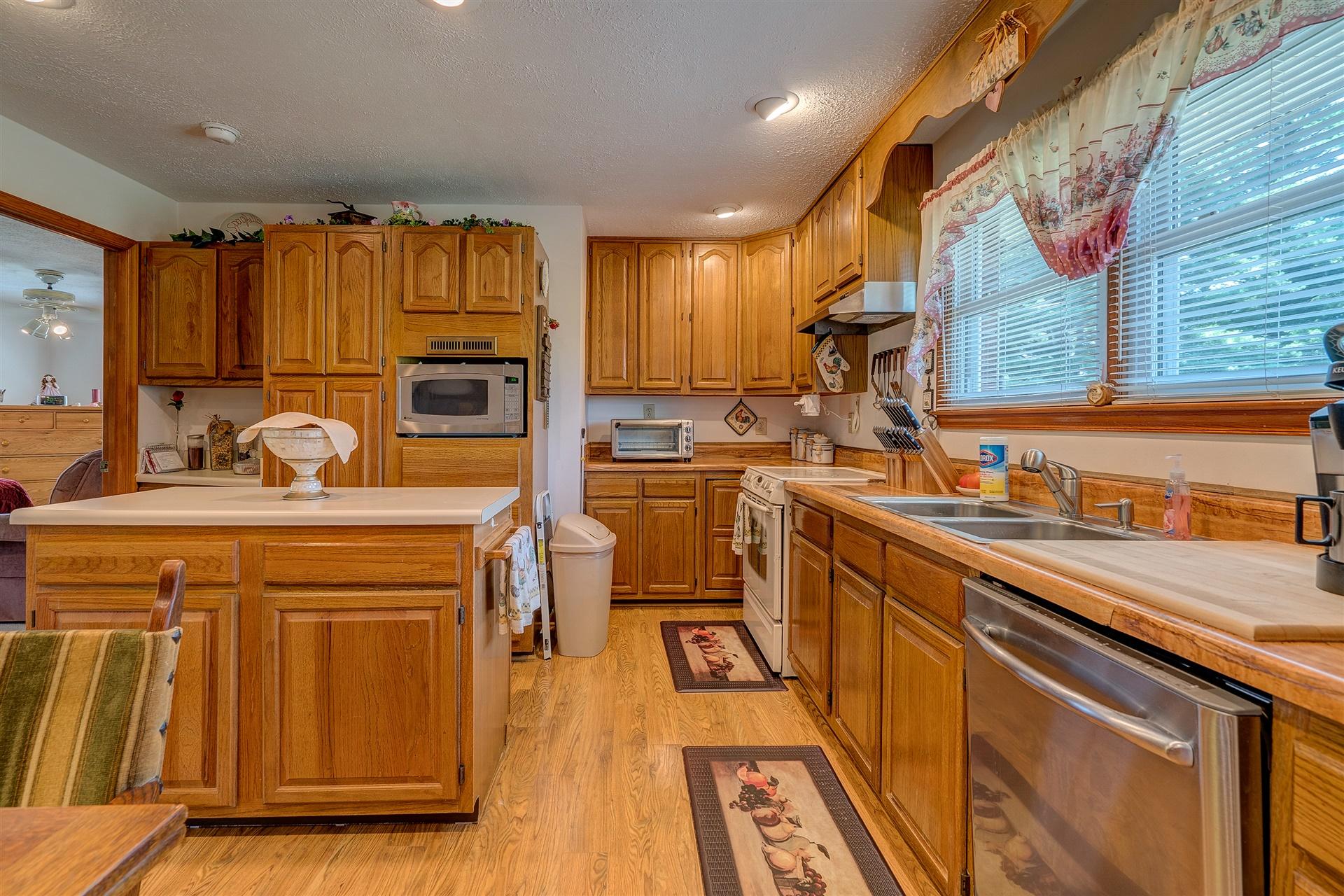 5756 White House Road Moneta, VA 24121 - Photo 13 of 35 a kitchen with stainless steel appliances granite countertop a sink a stove and a refrigerator