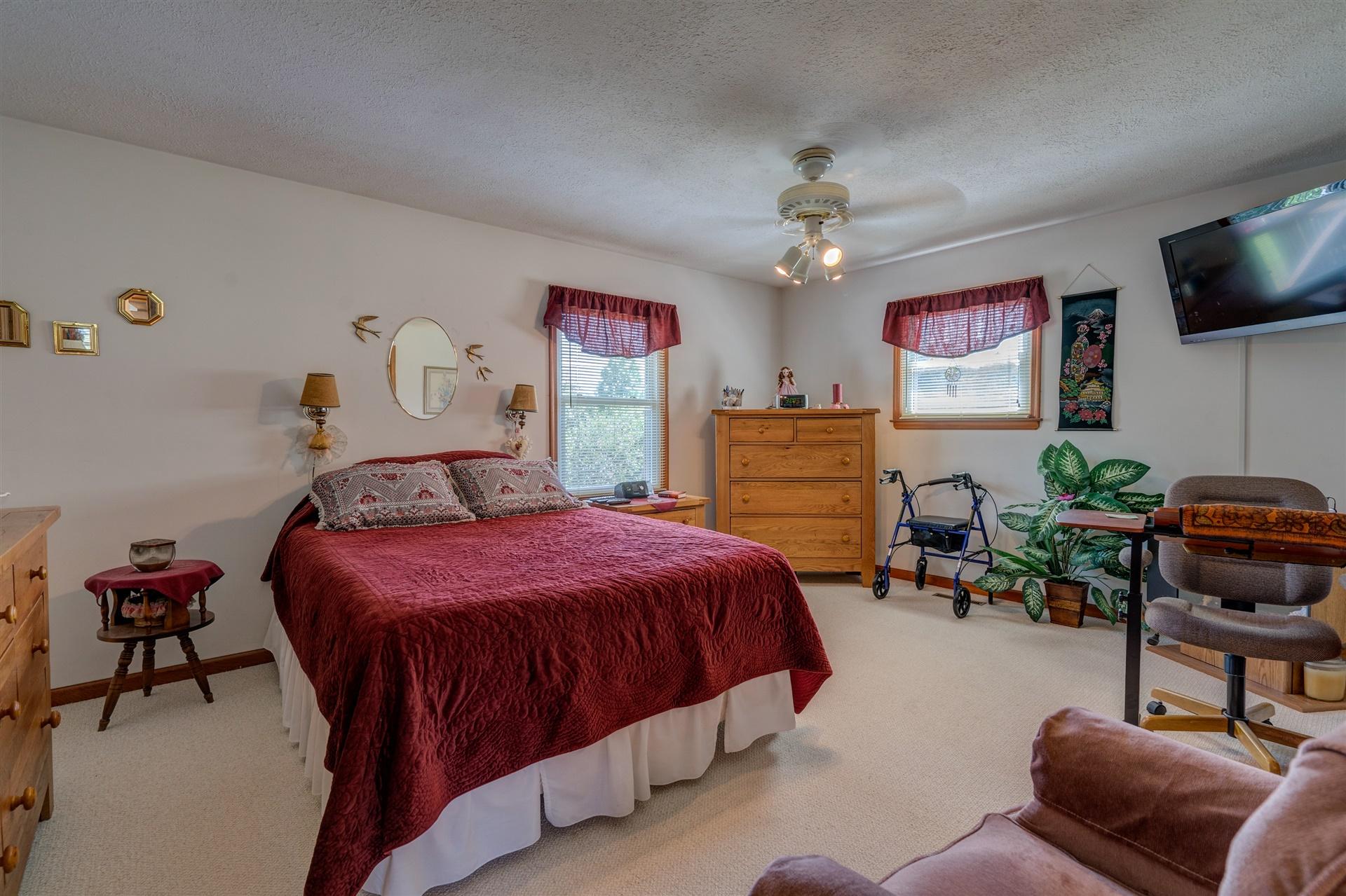 5756 White House Road Moneta, VA 24121 - Photo 14 of 35 a bedroom with a bed a chair and a flat tv screen on the dresser