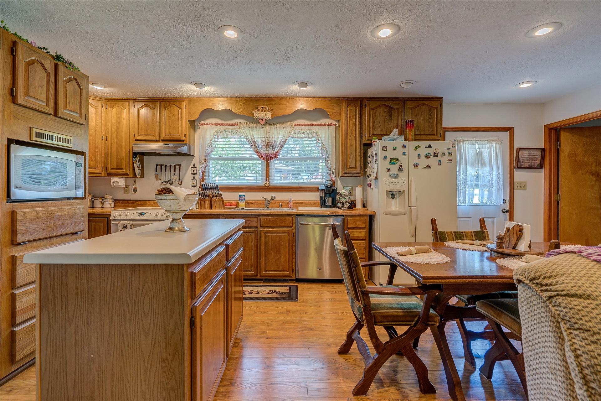 5756 White House Road Moneta, VA 24121 - Photo 9 of 35 a kitchen with stainless steel appliances kitchen island granite countertop a table chairs and a refrigerator