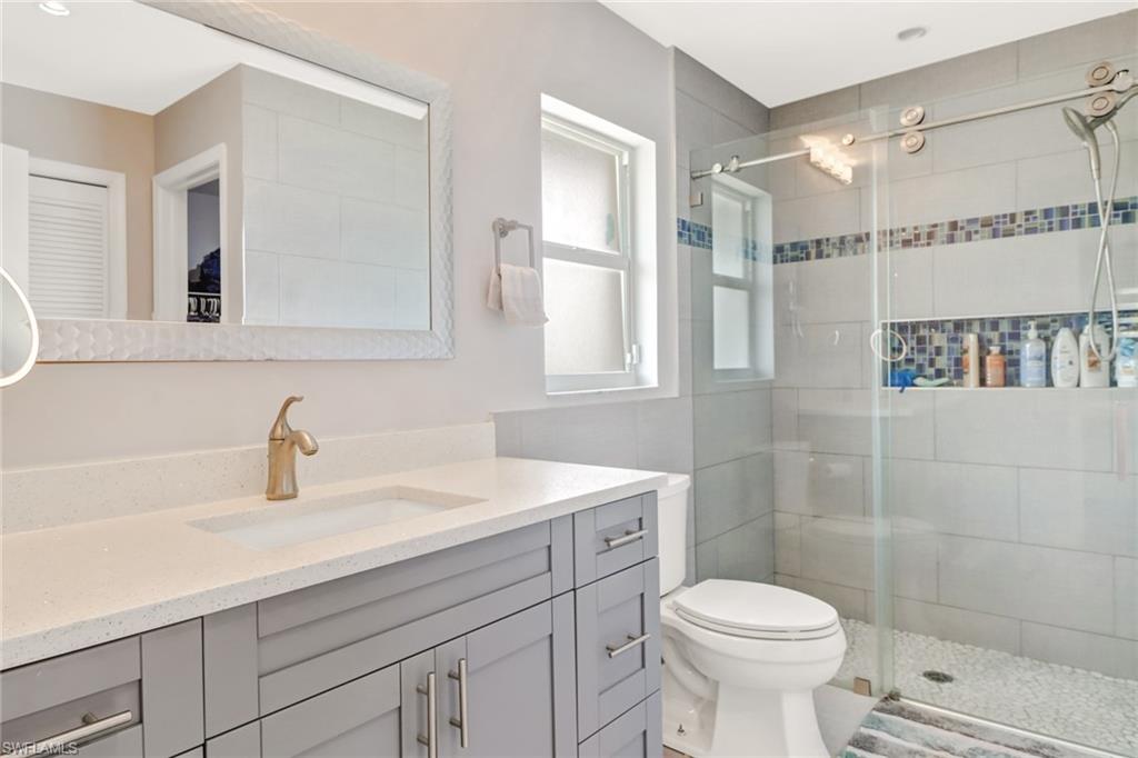 5131 31st Place Southwest Naples, FL 34116 - Photo 14 of 24 a bathroom with a sink toilet a mirror and shower