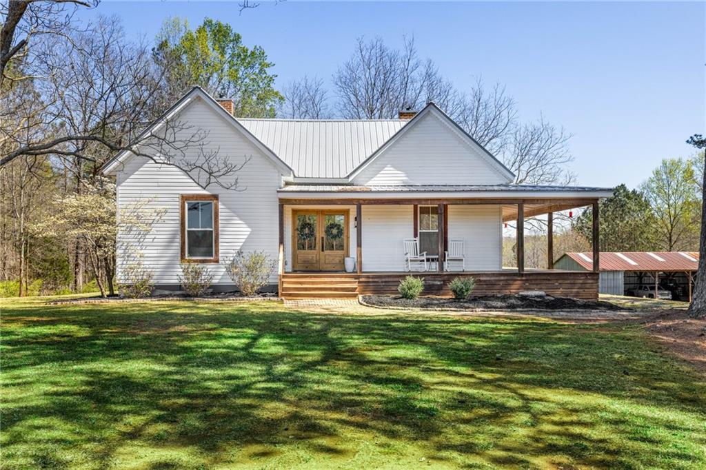 2445 Lyle Field Road Jefferson, GA 30549 - Photo 1 of 1 a front view of a house with a garden and trees