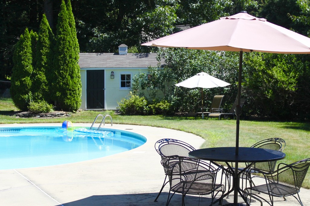 8 Brookside Lane Sterling, MA 01564 - Photo 25 of 26 a view of a swimming pool with a table and chairs under an umbrella