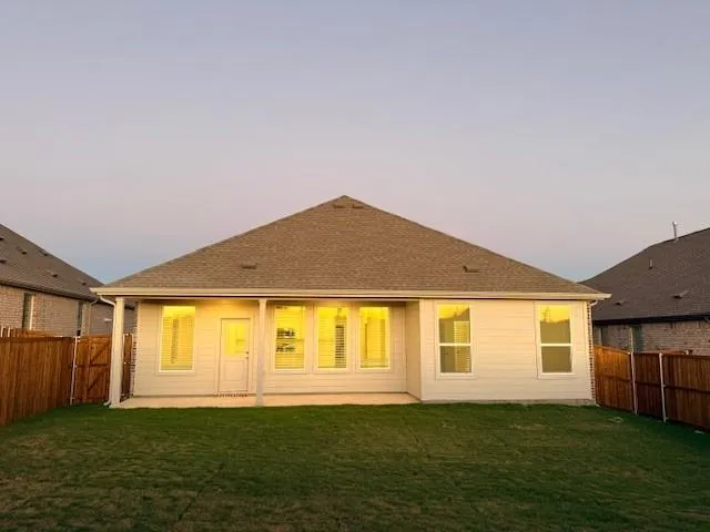 a big house with a big yard and large trees with wooden fence