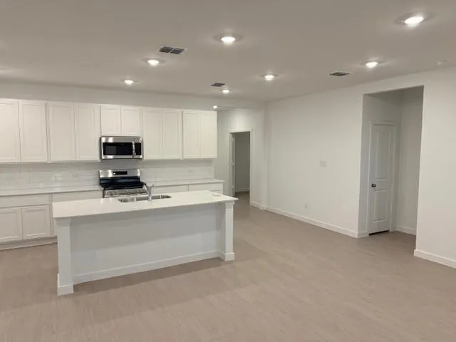 a kitchen with stainless steel appliances granite countertop a stove a sink and a refrigerator