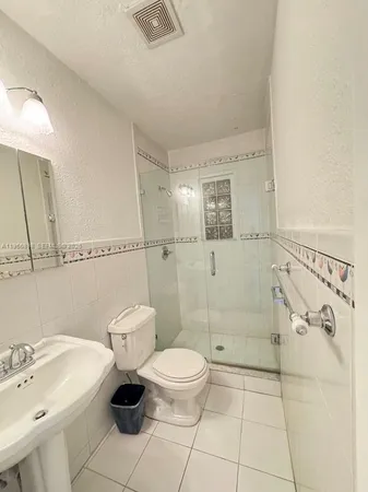 a bathroom with a toilet sink and shower
