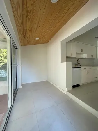 a view of a kitchen with a sink and a refrigerator