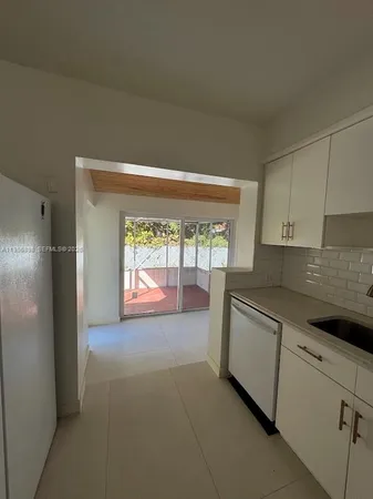 a large kitchen with cabinets and a wooden floor