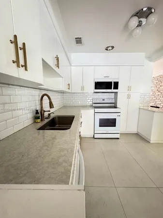 a kitchen with a sink and a stove top oven
