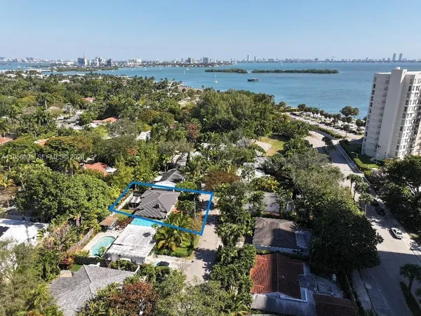 an aerial view of a city with lots of residential buildings ocean and mountain view in back