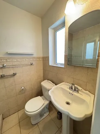 a bathroom with a sink a toilet and a mirror