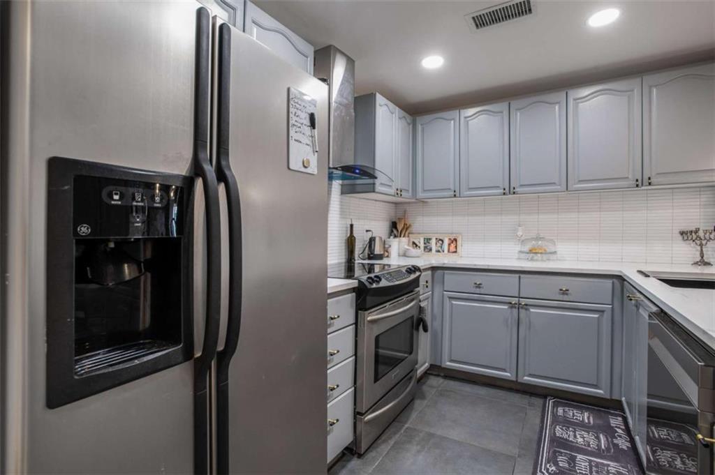 3475 Oak Valley Road Northeast, Unit 1630 Atlanta, GA 30326 - Photo 17 of 38 a kitchen with stainless steel appliances granite countertop white refrigerator a sink and white cabinets