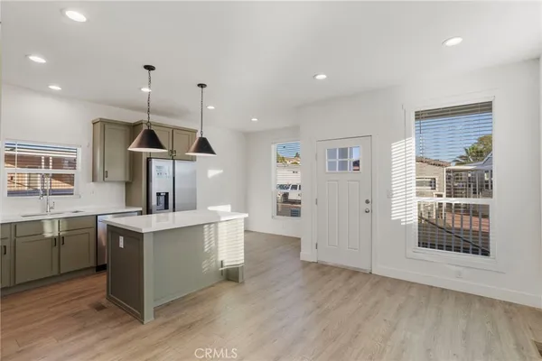 a kitchen with stainless steel appliances granite countertop a sink a stove and a wooden floors