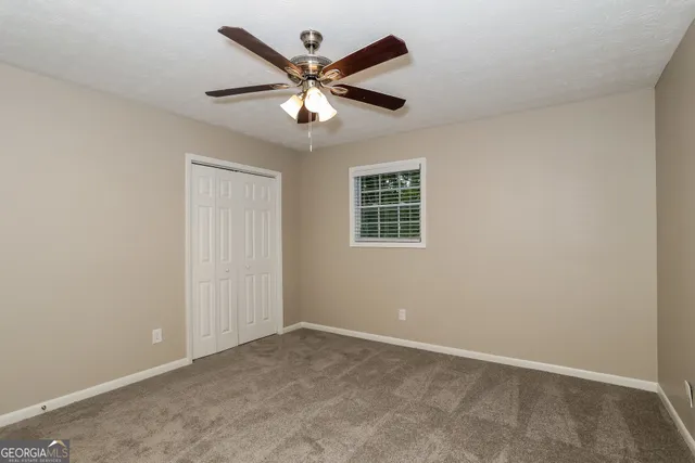 an empty room with a window and a fan