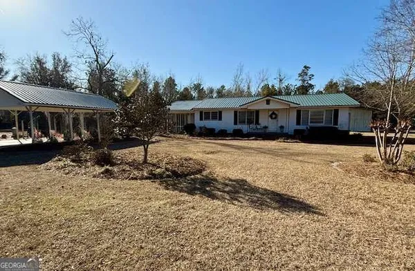 a front view of a house with a yard covered in snow