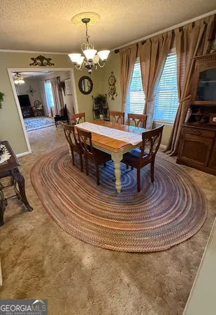 a dining room with furniture a rug and a chandelier