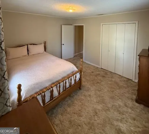 a bedroom with a bed and a wooden floor