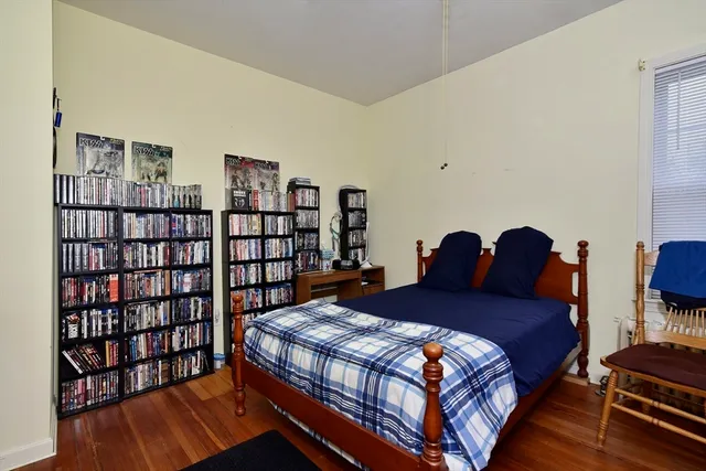 a living room with furniture a bookshelf and a window