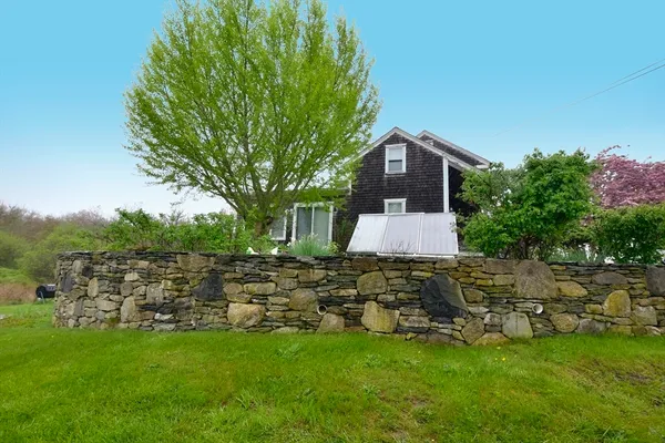 a front view of a house with a garden