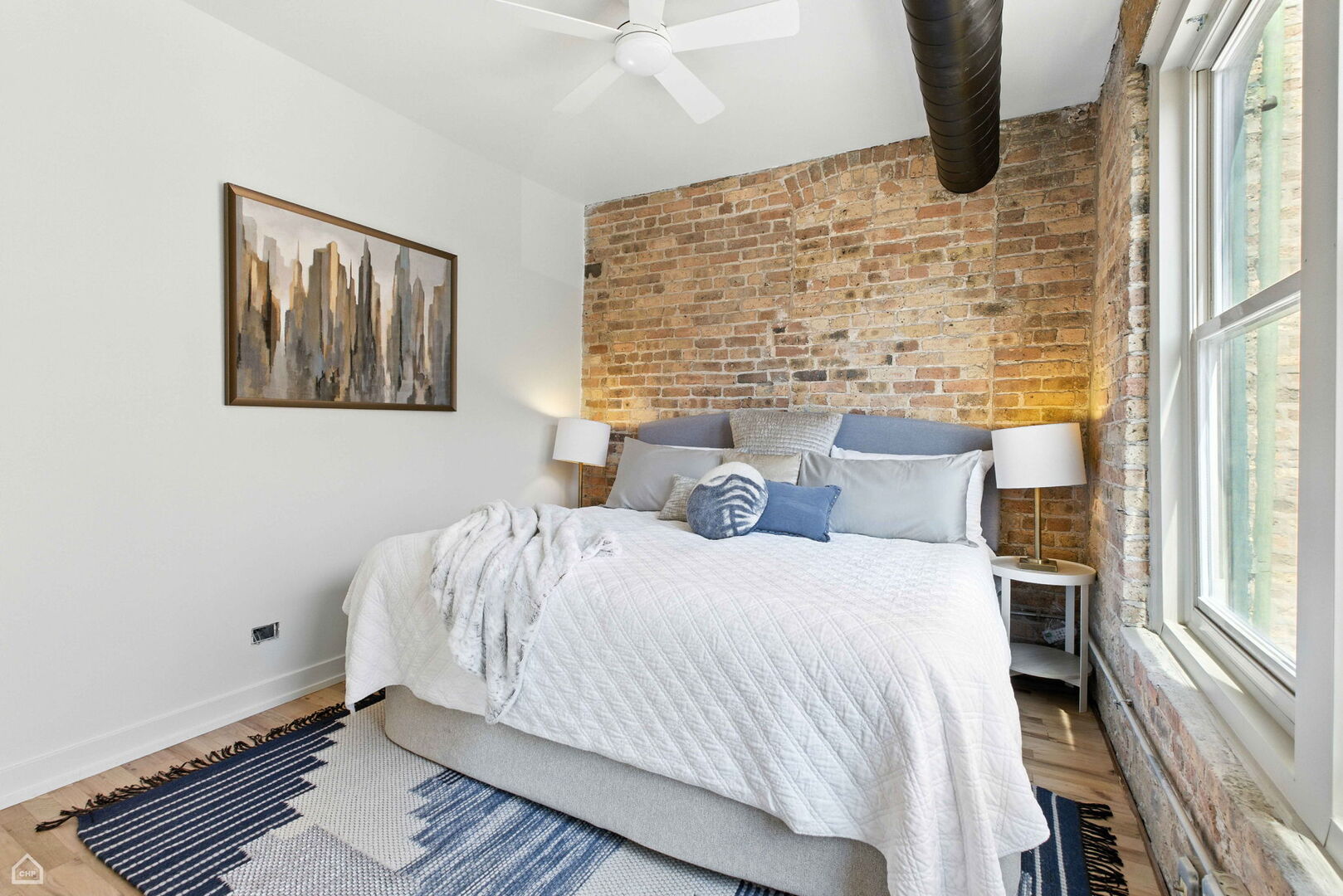 515 North Noble Street, Unit 308 Chicago, IL 60642 - Photo 10 of 13 a bedroom with a bed and wooden floor