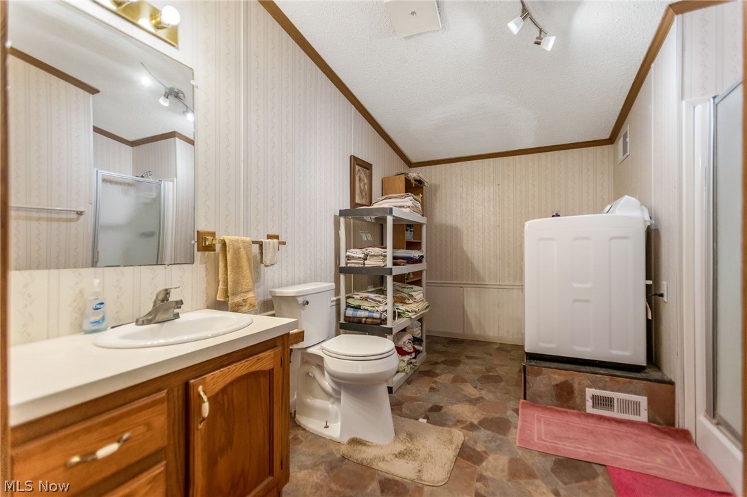 4502 Clover Road Cumberland, OH 43732 - Photo 16 of 38 Master Bathroom with a stall shower, rail lighting, wallpapered walls, ornamental molding, and vanity