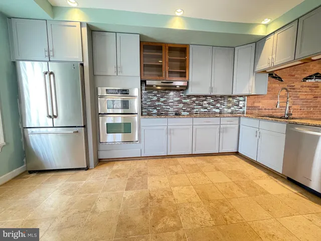 a kitchen with stainless steel appliances granite countertop a refrigerator and a sink