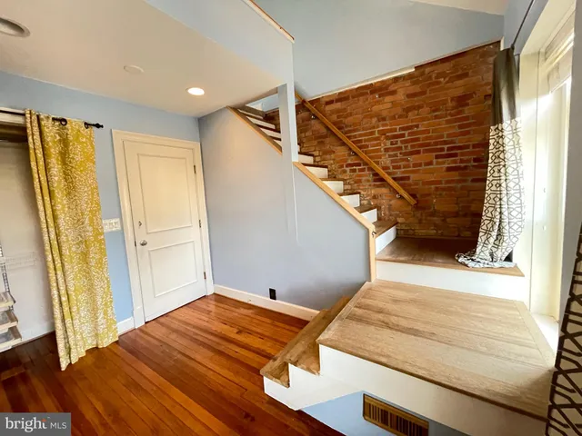 a view of a room with wooden floor and windows