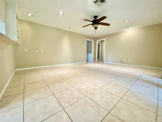 a view of an empty room and a ceiling fan
