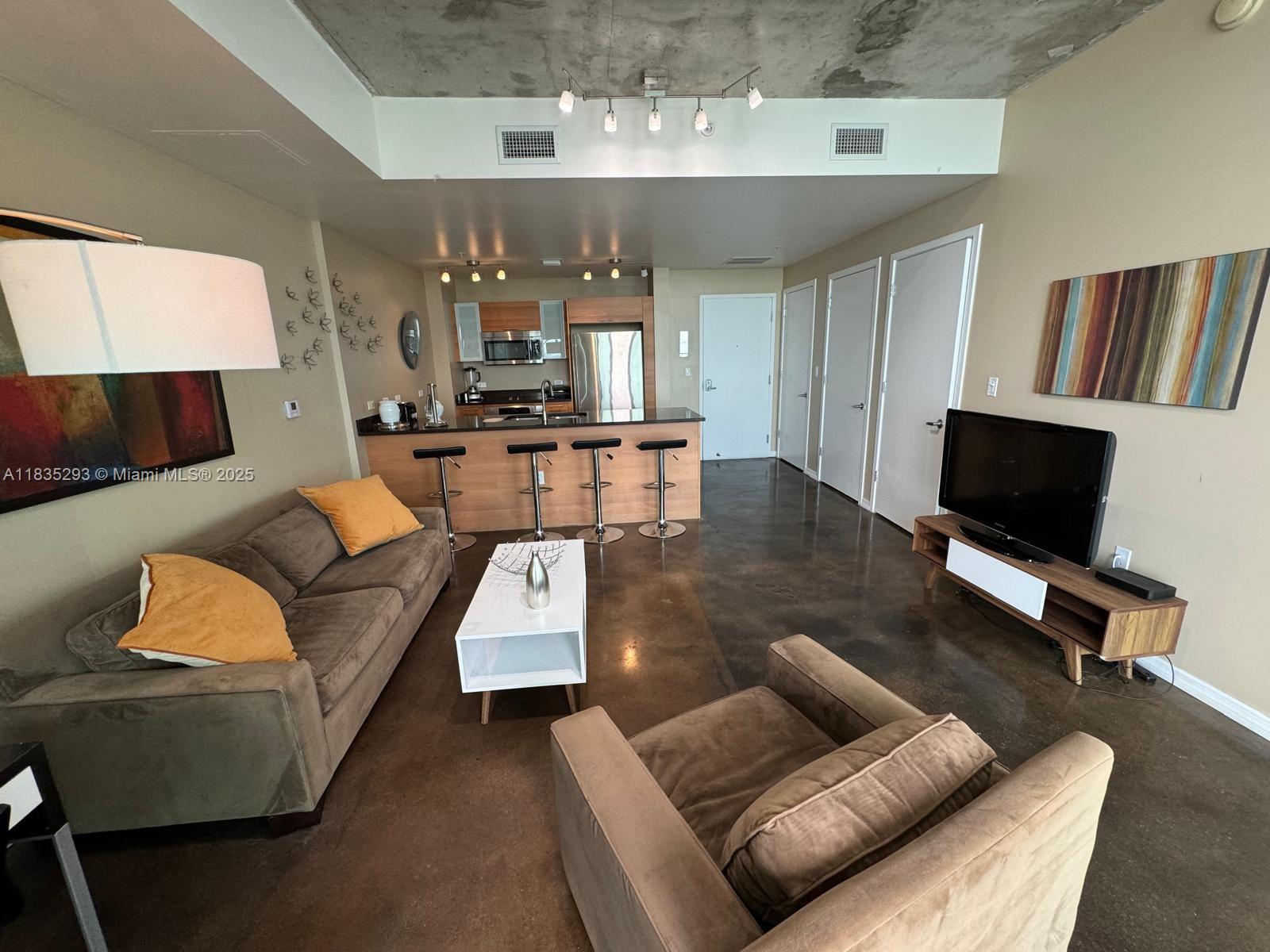 3301 Northeast 1st Avenue, Unit H2903 Miami, FL 33137 - Photo 1 of 20 a living room with furniture and a flat screen tv