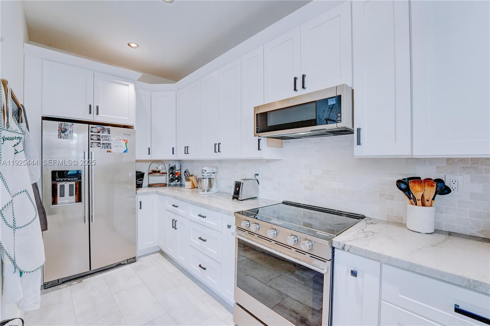 12771 Southwest 133rd Street Miami, FL 33186 - Photo 17 of 39 a kitchen with stainless steel appliances a stove microwave and refrigerator