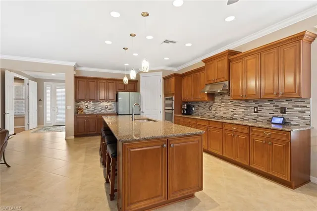 a kitchen with stainless steel appliances granite countertop a sink a stove and a refrigerator