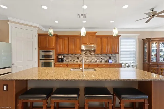 a kitchen with a table chairs sink and cabinets
