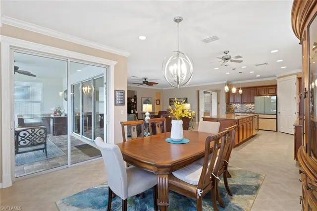 a view of a dining room and livingroom with furniture wooden floor a chandelier