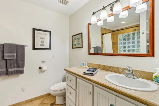 a bathroom with a granite countertop sink mirror and toilet