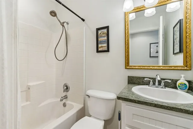 a bathroom with a granite countertop sink a toilet and a mirror