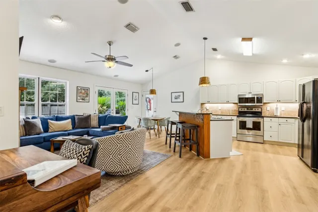 a living room with lots of furniture and kitchen view