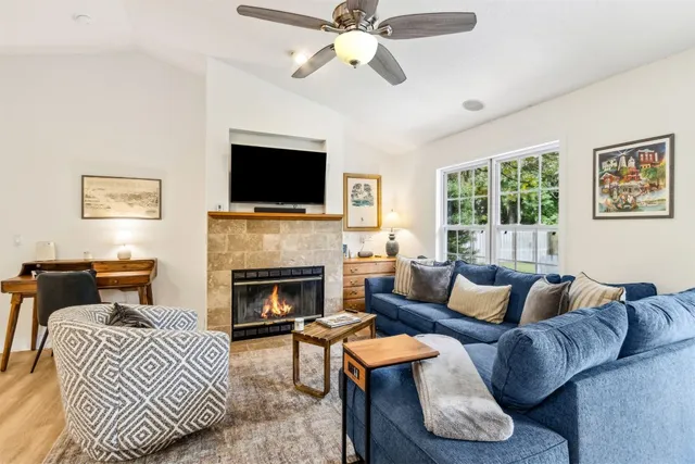 a living room with furniture a flat screen tv and a fireplace