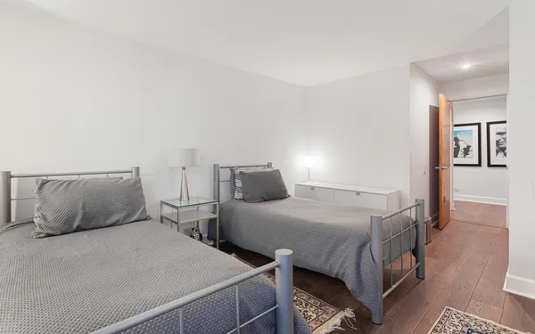 a bedroom with two beds and painting on the wall