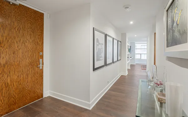 a view of a hallway with wooden floor and staircase