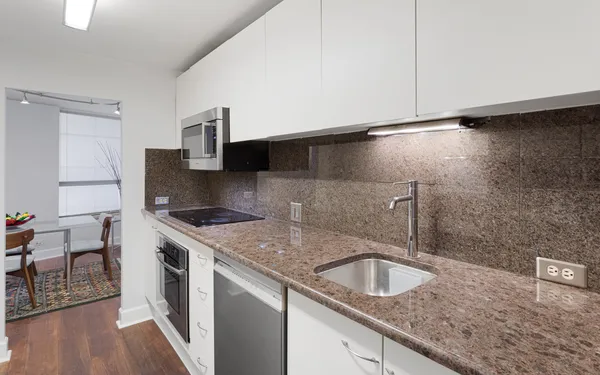 a kitchen with granite countertop a sink and a stove
