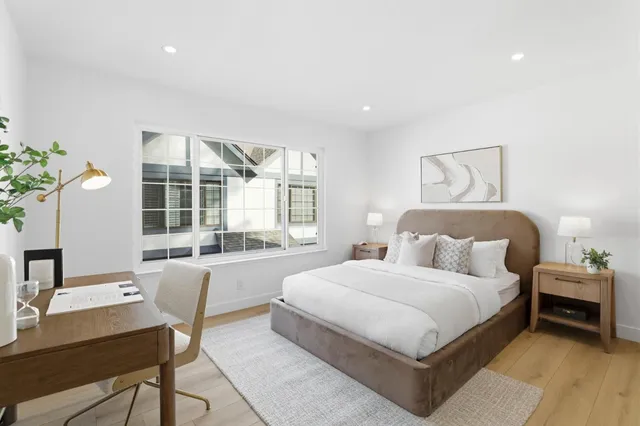 a large bedroom with a bed and large window