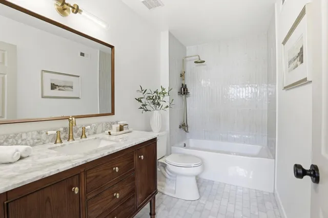 a bathroom with a granite countertop sink toilet and shower