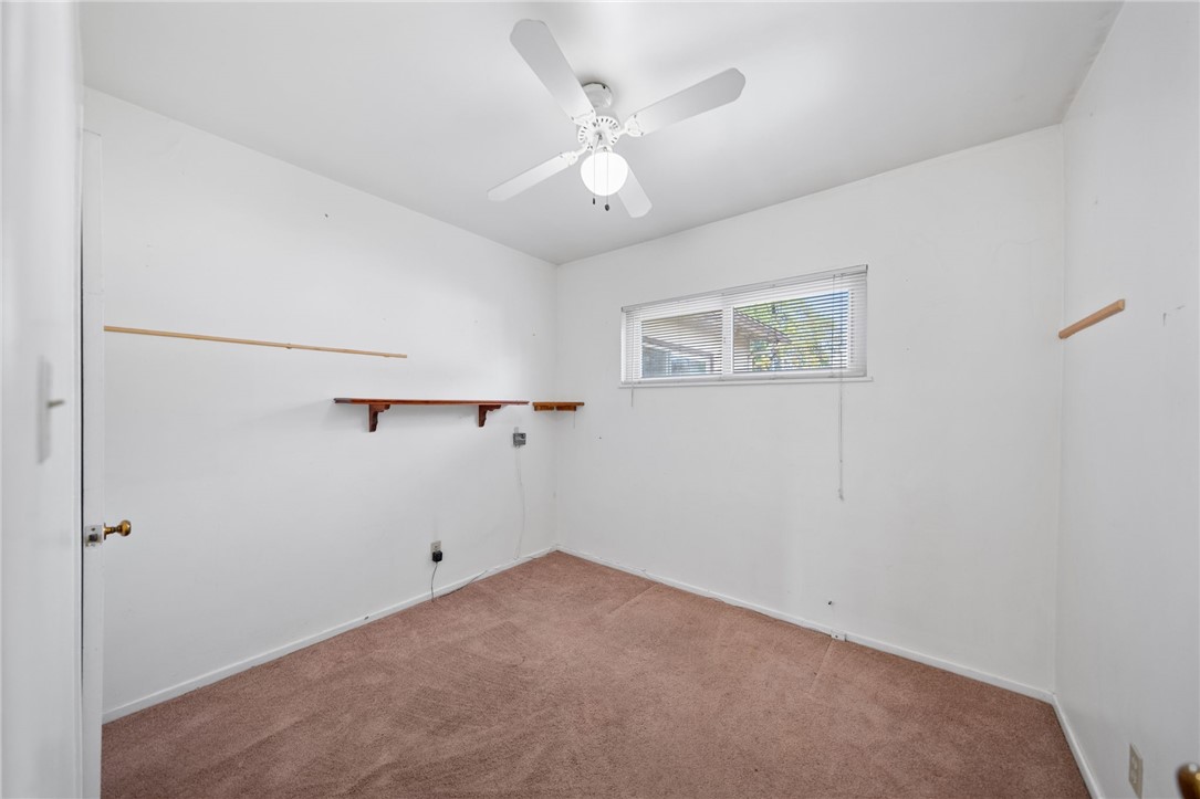 3075 David Street Riverside, CA 92506 - Photo 15 of 40 Versatile room with ceiling fan, natural light, and wall shelving—ideal for a home office, hobby room, or guest space.